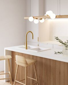 a kitchen with white counter tops and wooden stools next to a sink under a mirror