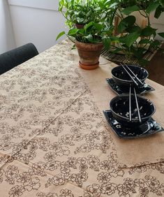 a table topped with black plates covered in floral design on top of a wooden table