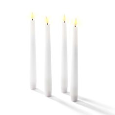 three white candles with yellow light coming from them