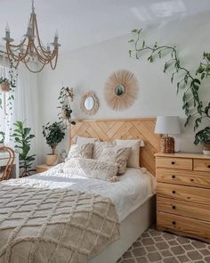 a bed sitting in a bedroom under a chandelier next to a wooden dresser