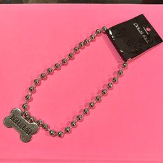 a pink box with a dog tag on it and a ball chain attached to it