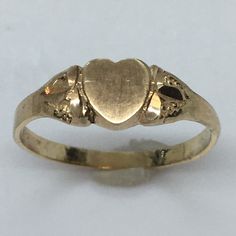 Antique Heart Shape 14K GOLD Signet RIng 1.0 Gram Size 5.25 Never Engraved This antique signet ring is a true beauty. Crafted from 14k yellow gold, it features a heart-shaped design that exudes elegance and sophistication. The ring is perfect for any occasion and is a great addition to any jewelry collection. With a weight of 1.0 gram and a size of 5.25, this ring is a perfect fit for anyone. It has never been engraved and does not feature any diamonds or gemstones. The vintage design adds to its charm and makes it a unique piece. Don't miss out on the opportunity to own this exquisite piece of fine jewelry. 6 mm wide on top Heirloom 14k Gold Heart Promise Ring, Vintage Yellow Gold Engraved Promise Ring, Victorian Style 14k Yellow Gold Signet Ring, Antique Yellow Gold Heart Cut Jewelry, Victorian 14k Gold Jewelry For Valentine's Day, Victorian Yellow Gold Jewelry For Valentine's Day, Vintage 14k Gold Diamond-cut Signet Ring, Vintage 14k Gold Diamond Cut Signet Ring, Vintage 14k Gold Signet Ring With Diamond Cut