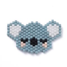 a blue and white beaded brooch with an animal face on it's side