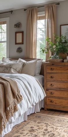 a large bed sitting next to two windows in a bedroom