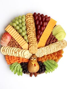 a turkey shaped platter filled with cheese, crackers, grapes, and nuts