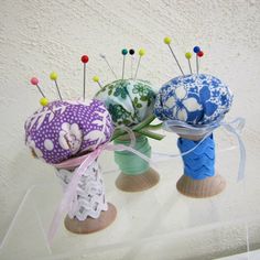 three small vases with different designs on them