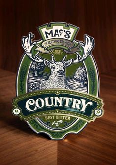 the logo for mas's country beer is shown on a wooden table with an image of a deer