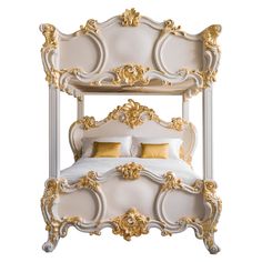 a white bed with gold trimmings on the headboard and foot board, in front of a white background