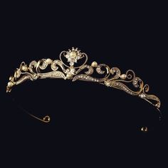 a gold tiara with pearls and diamonds on the headpiece, possibly an ornament