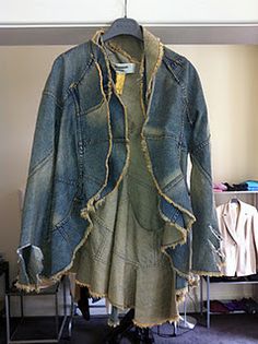 an old jean jacket is hanging on a clothes hanger in a room with other items