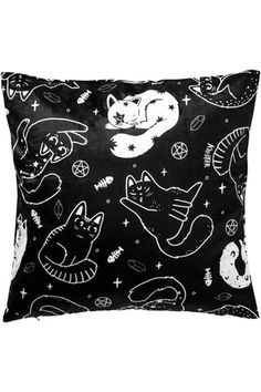 a black and white pillow with cats, stars and other things on it's side