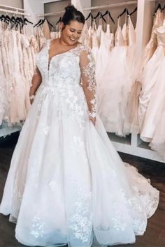 a woman standing in front of some wedding dresses