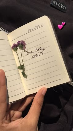 someone is holding an open notebook with writing on it that says, you are loved