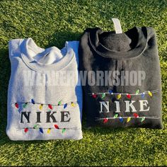 two t - shirts that say nike and have lights on them in front of green grass