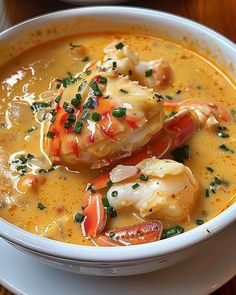 a white bowl filled with soup and shrimp