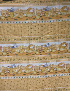 an old yellow and white quilt with cats on it