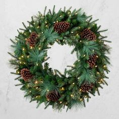 a christmas wreath with pine cones and lights