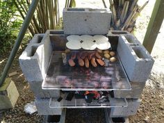 an outdoor grill with plates and food cooking on it