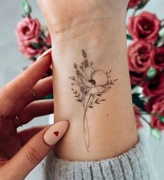 a woman's wrist with a flower tattoo on it