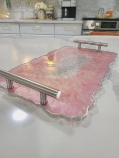 a pink and silver tray sitting on top of a kitchen counter next to a stove