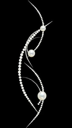 a white pearl and diamond necklace on a black background