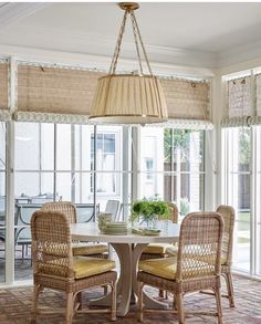 a dining room table with two chairs and a chandelier hanging from the ceiling