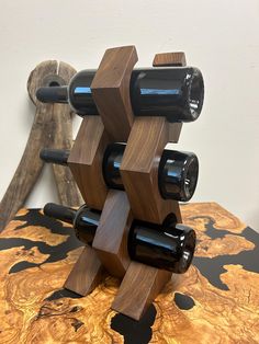 a wine rack made out of wood with bottles in it on a table next to a wall