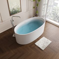 a bath tub sitting on top of a hard wood floor next to a potted plant