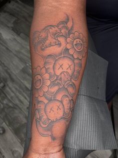 a person with a tattoo on their arm holding a cell phone in one hand and a clock in the other