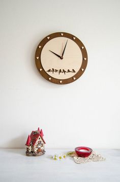 a clock on the wall next to a small house