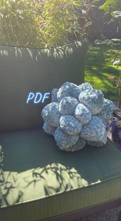 a pile of rocks sitting on top of a green chair next to a pillow with the word pddf written on it