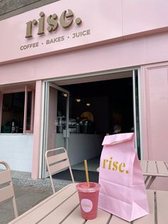 a pink bag sitting on top of a wooden table next to a coffee shop window