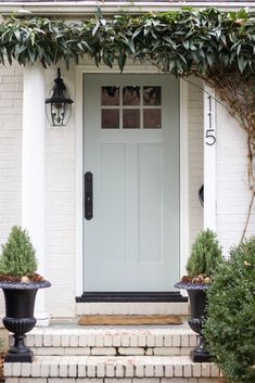 a white front door with two black planters