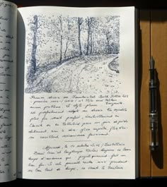 an open book with writing on it next to a fountain pen and ink drawing brush