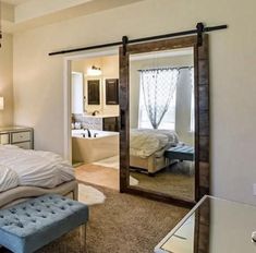 a bedroom with a bed, mirror and vanity in the corner next to a bathtub