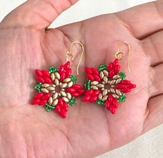 These Poinsettia Earrings capture the holiday spirit with a stunning floral design. Crafted using vibrant red and gold super duo glass beads, complemented by green seed beads, they resemble the iconic poinsettia flower. Finished with gold-colored earring wires, these earrings are a cheerful and festive addition to any outfit. Lightweight and eye-catching, they are perfect for Christmas parties, holiday gatherings, or as a thoughtful gift for someone who loves seasonal accessories. Celebrate the Diy Earrings Christmas, Christmas Beaded Earrings, Beading Earring, Beaded Crosses, Poinsettia Earrings, Christmas Beading, Christmas Jewelry Diy, Beaded Projects, Red Flower Earrings