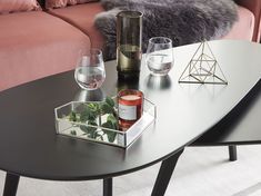 a table with two wine glasses, a candle holder and some other items on it