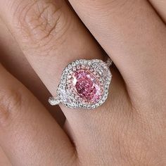 a woman's hand with a pink and white diamond ring