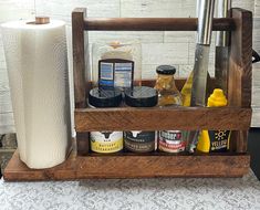 a wooden spice rack with spices and condiments in it on top of a table