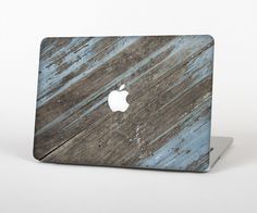 an apple laptop computer sitting on top of a wooden table covered in blue and white paint