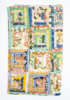 a multicolored patchwork quilt hanging on a wall