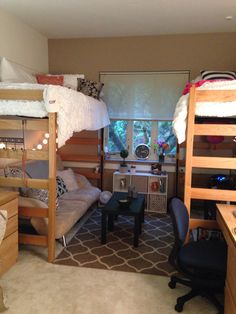 a bedroom with bunk beds and desks in the corner, along with other furniture