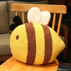 a stuffed bee sitting on top of a wooden chair