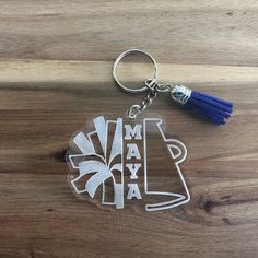 a keychain with a tassel hanging from it's side on a wooden surface