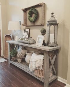 a wooden table topped with baskets filled with plants and other items next to a lamp