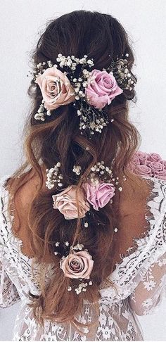 a woman with long hair and flowers in her hair is shown from the back view