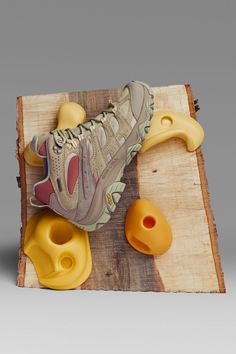 a pair of yellow shoes sitting on top of a piece of wood next to an orange object