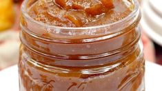 a glass jar filled with caramel sauce on top of a white plate