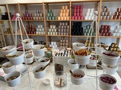 several buckets filled with different types of items on a table in front of shelves