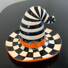 a black and white hat with an orange buckle on it's centerpieces